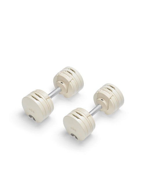 Close-up of NÜOBELL S 224 Sand adjustable dumbbell with sleek sand-colored finish designed for space-saving versatile strength training in any home gym
